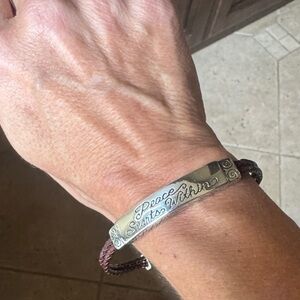 Brighton  Silver Bracelet with Brown Cord
Peace Starts Within